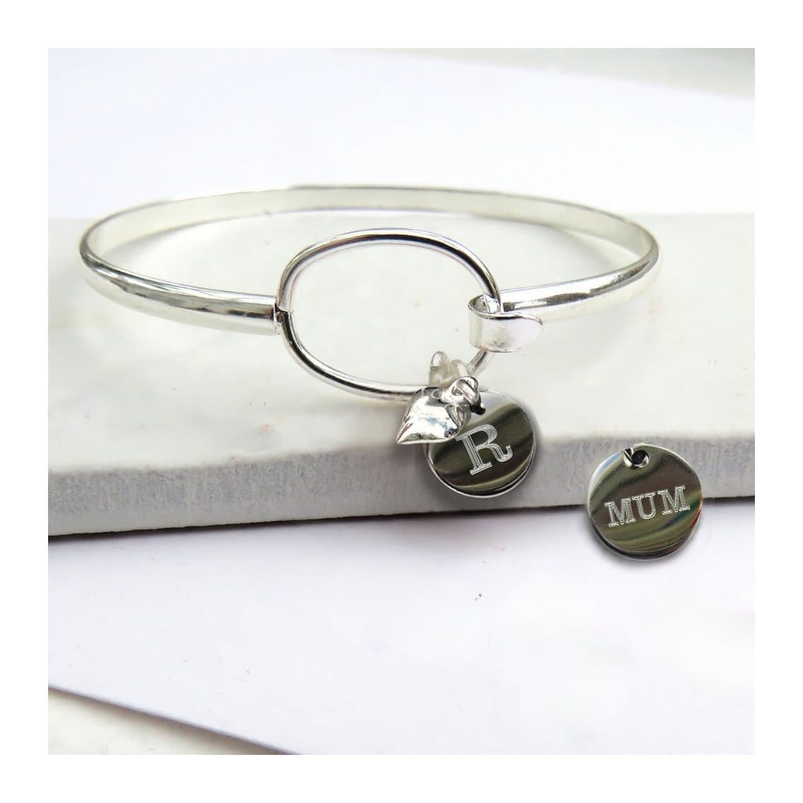 Silver bangle with a mini heart charm and a round silver coloured disc