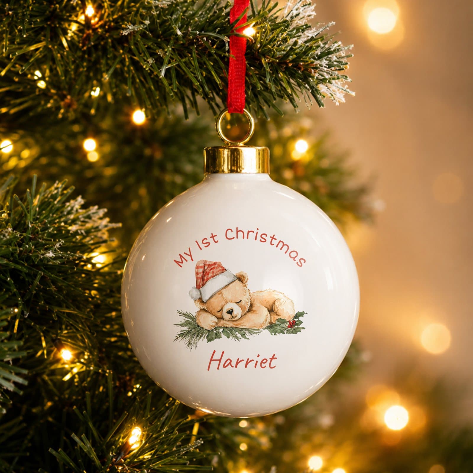 Ceramic Christmas bauble with a sleeping bear design and a ribbon