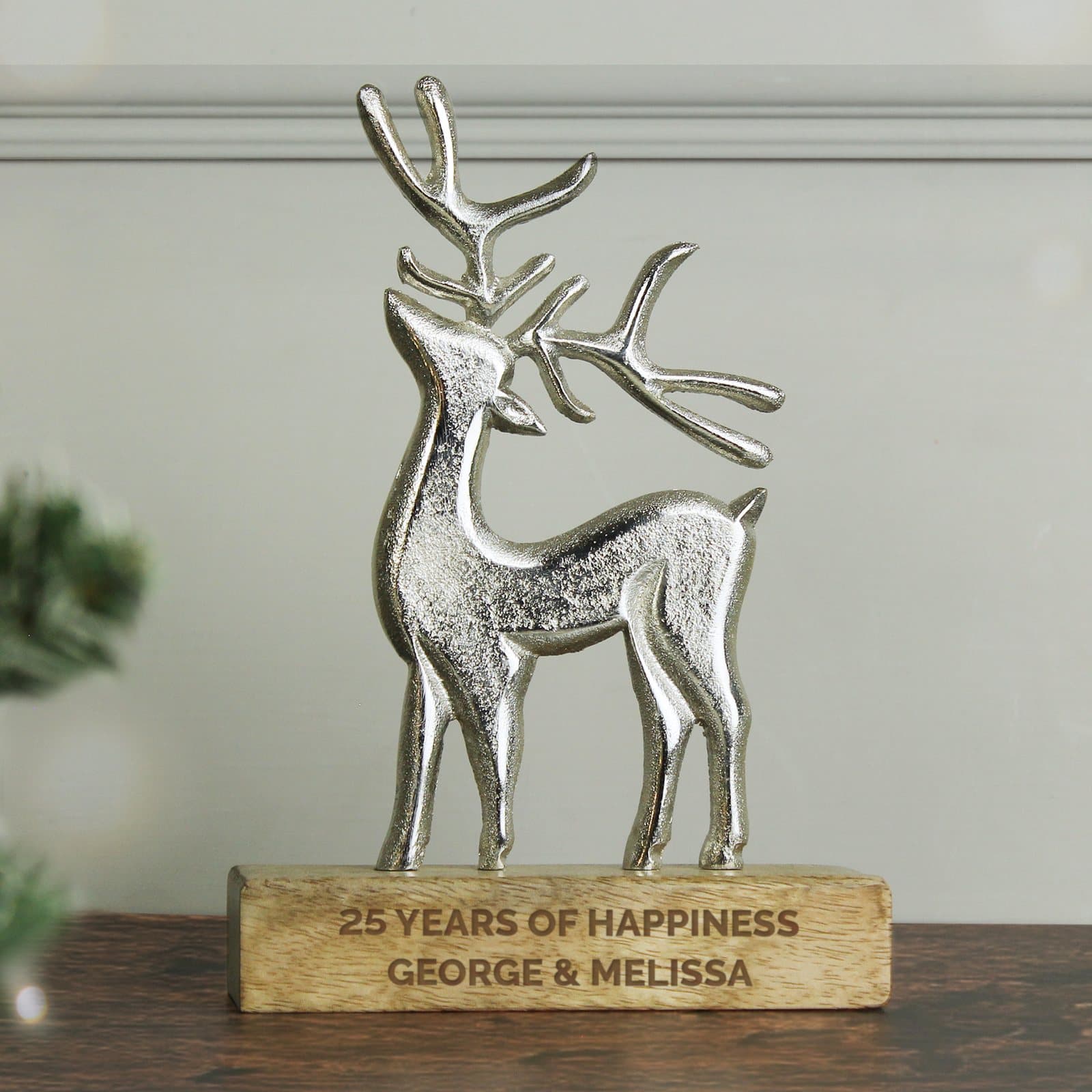 Textured metal stag ornament with antlers standing on a wooden base