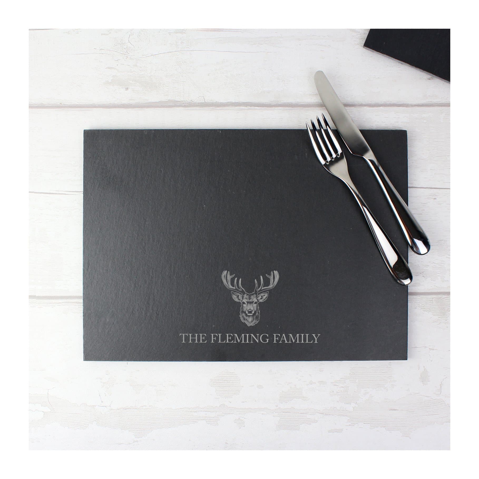 Slate placemat with a stag silhouette and a line of text
