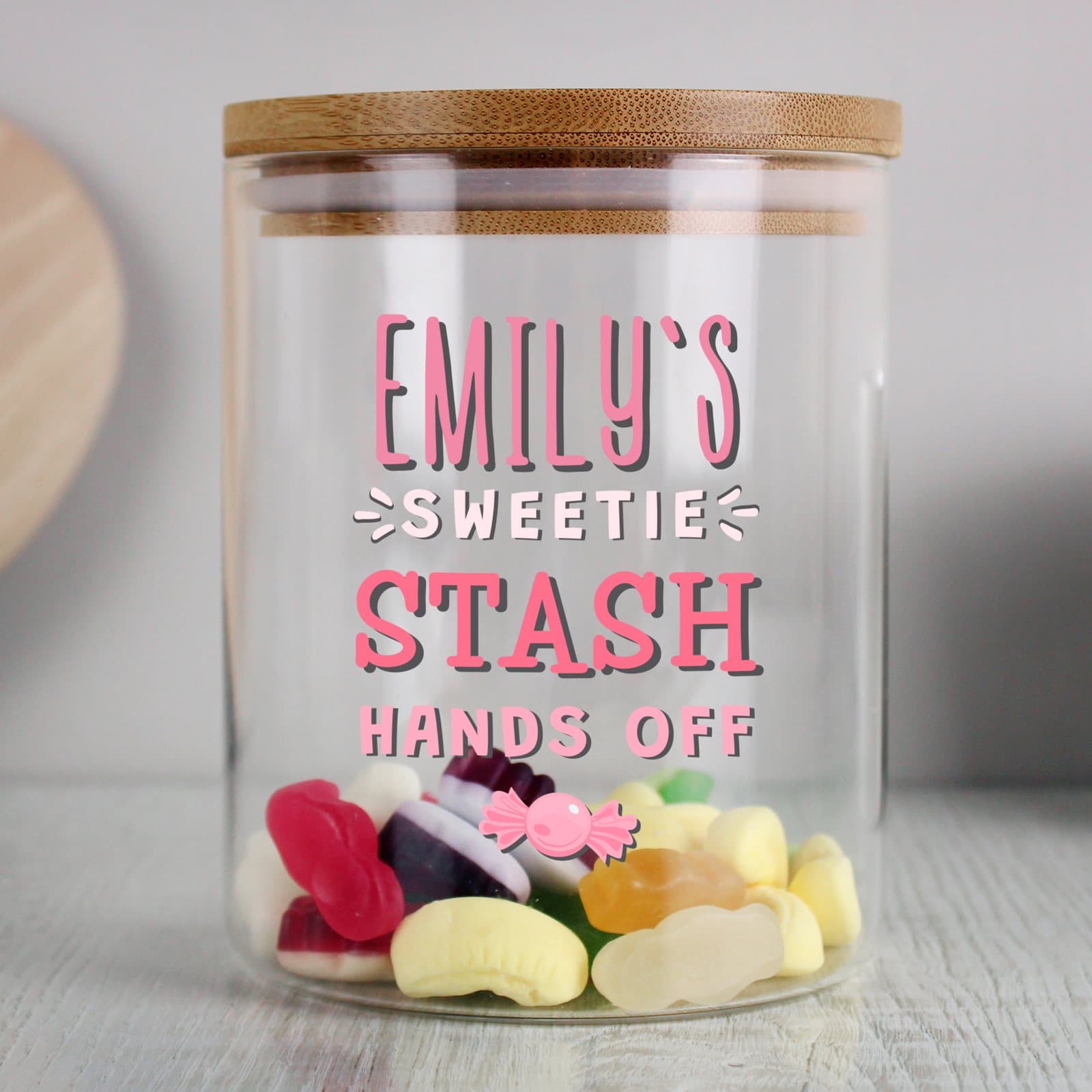 Glass jar with bamboo lid marked Sweetie Stash, Hands Off and a name