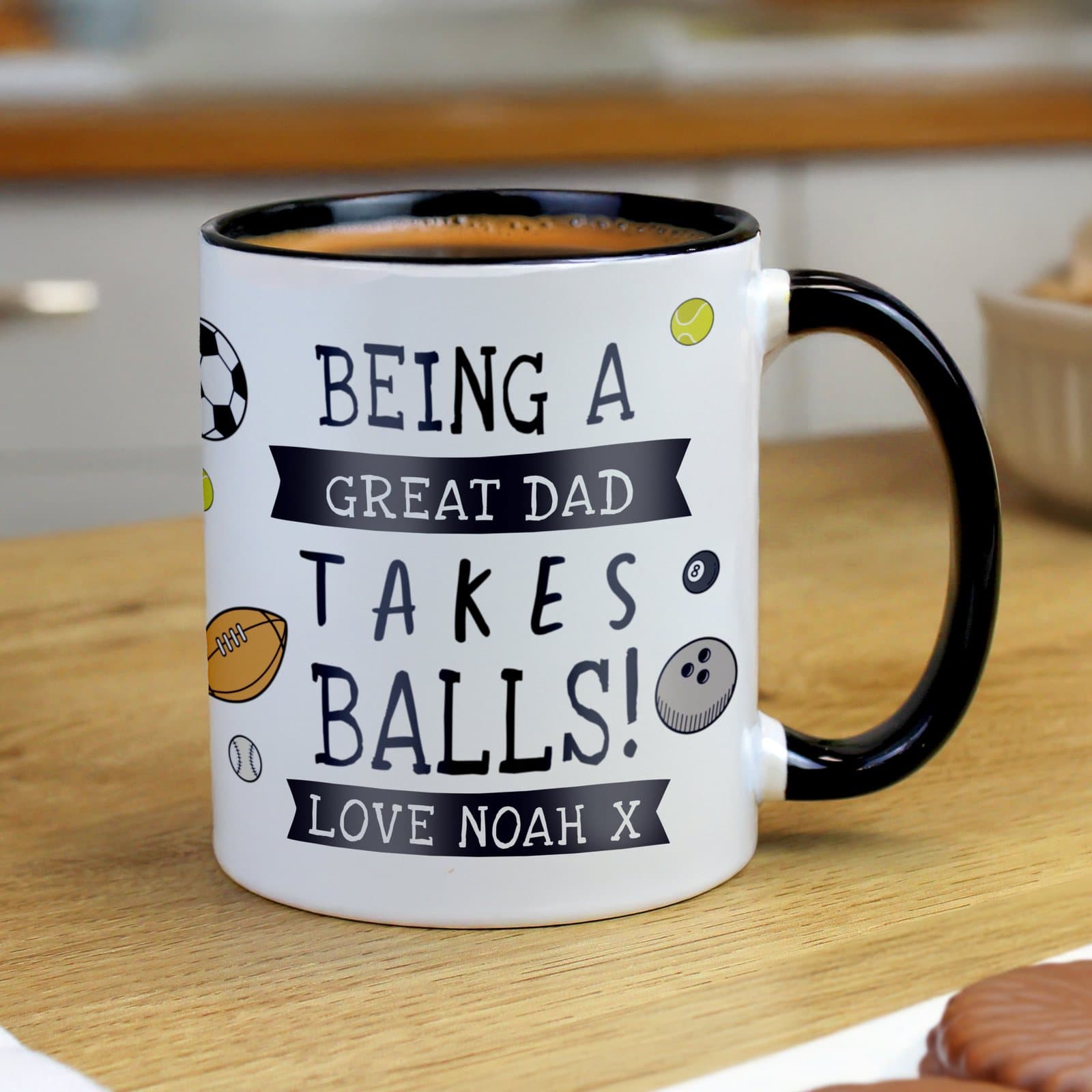 Ceramic mug with black handle and sports ball design