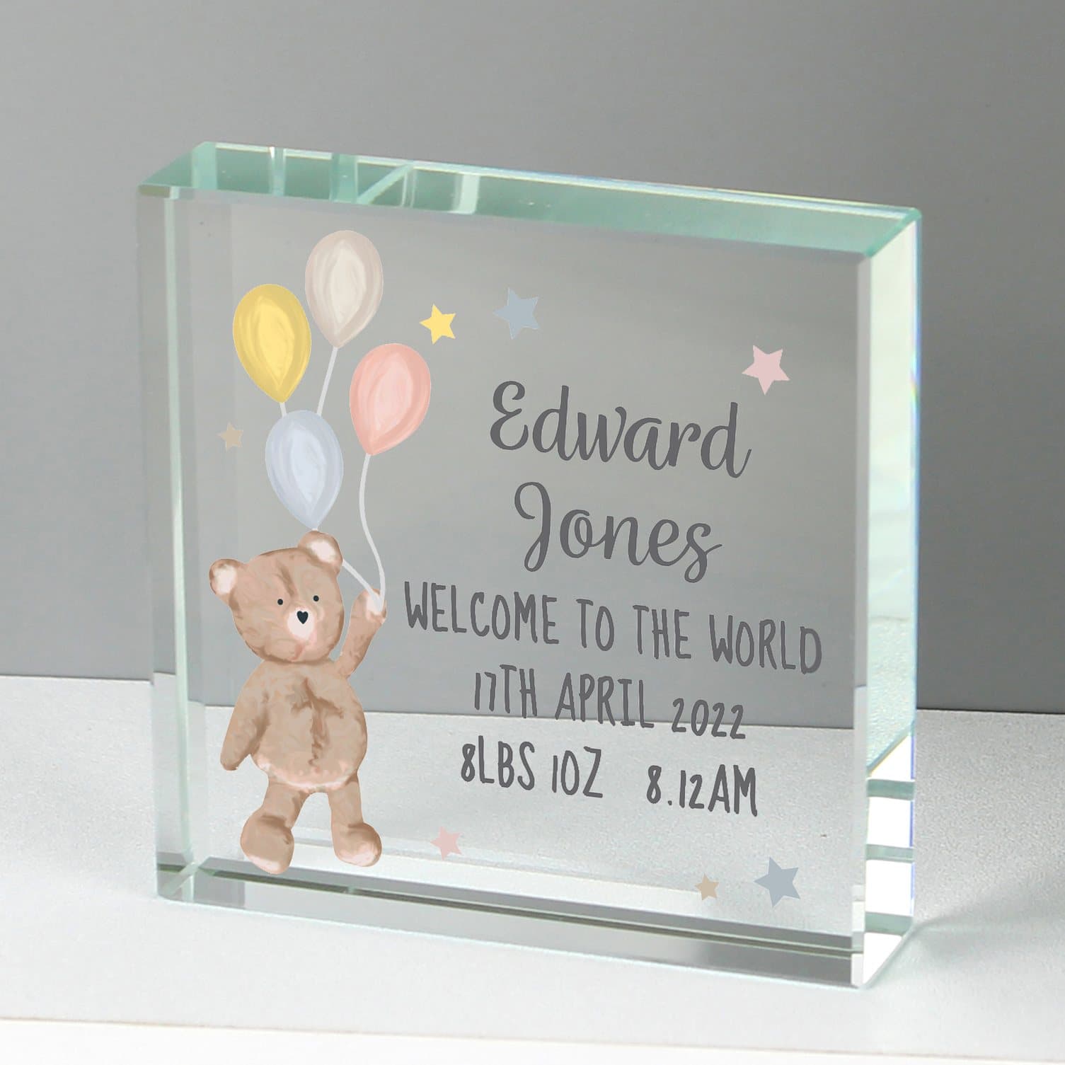 Square glass token with a teddy and balloons design and lines of text