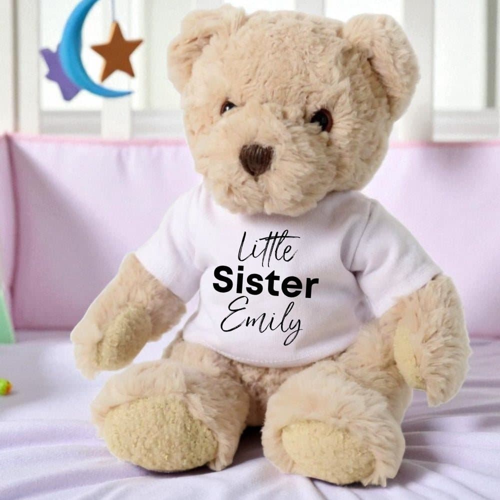 Teddy bear in a printed T-shirt that reads Little Sister in black