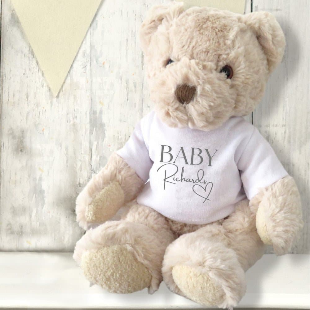 Teddy bear in a printed T-shirt with a surname and a little heart