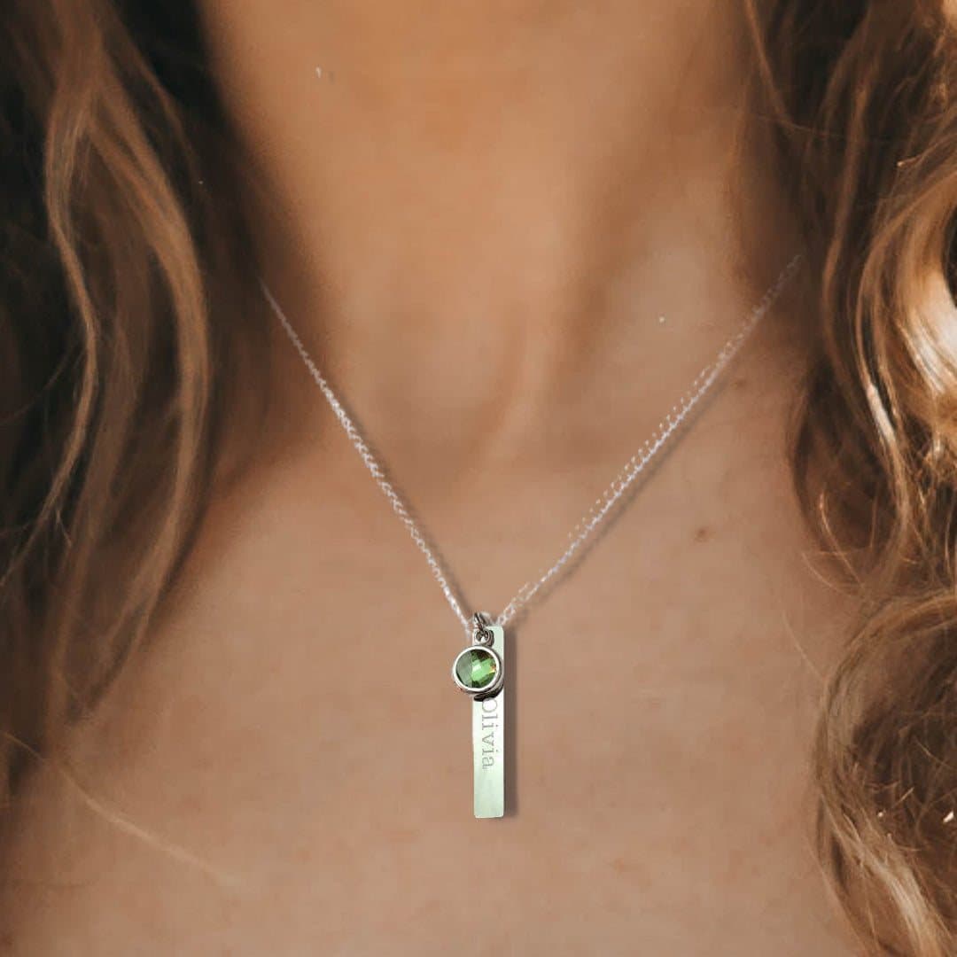 Thin silver coloured bar necklace with a birthstone charm on a chain