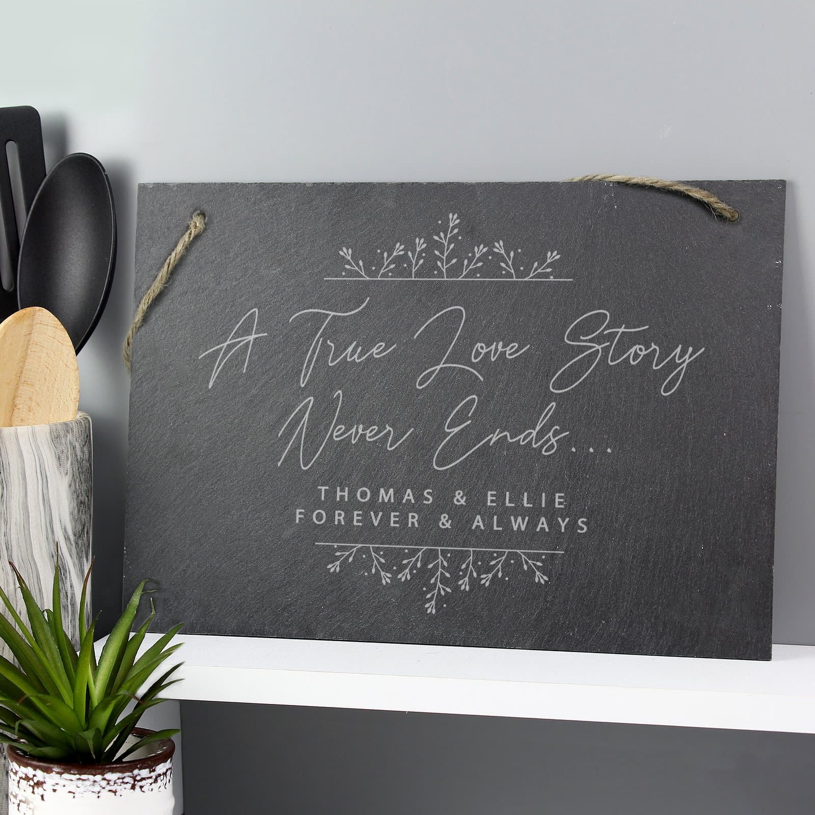 Hanging slate sign with A True Love Story Never Ends and an engraved message