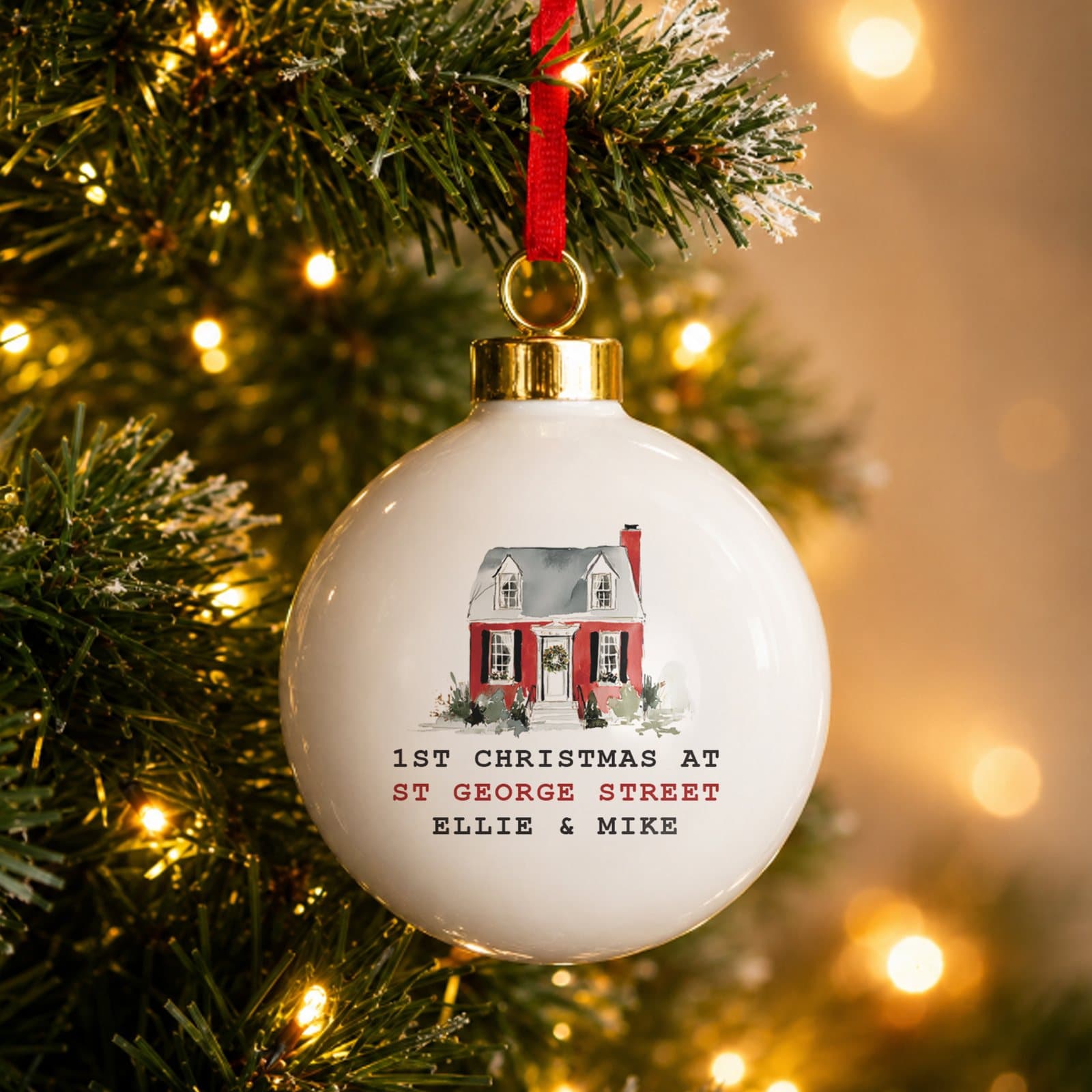 Ceramic Christmas bauble with a water colour house design and a ribbon