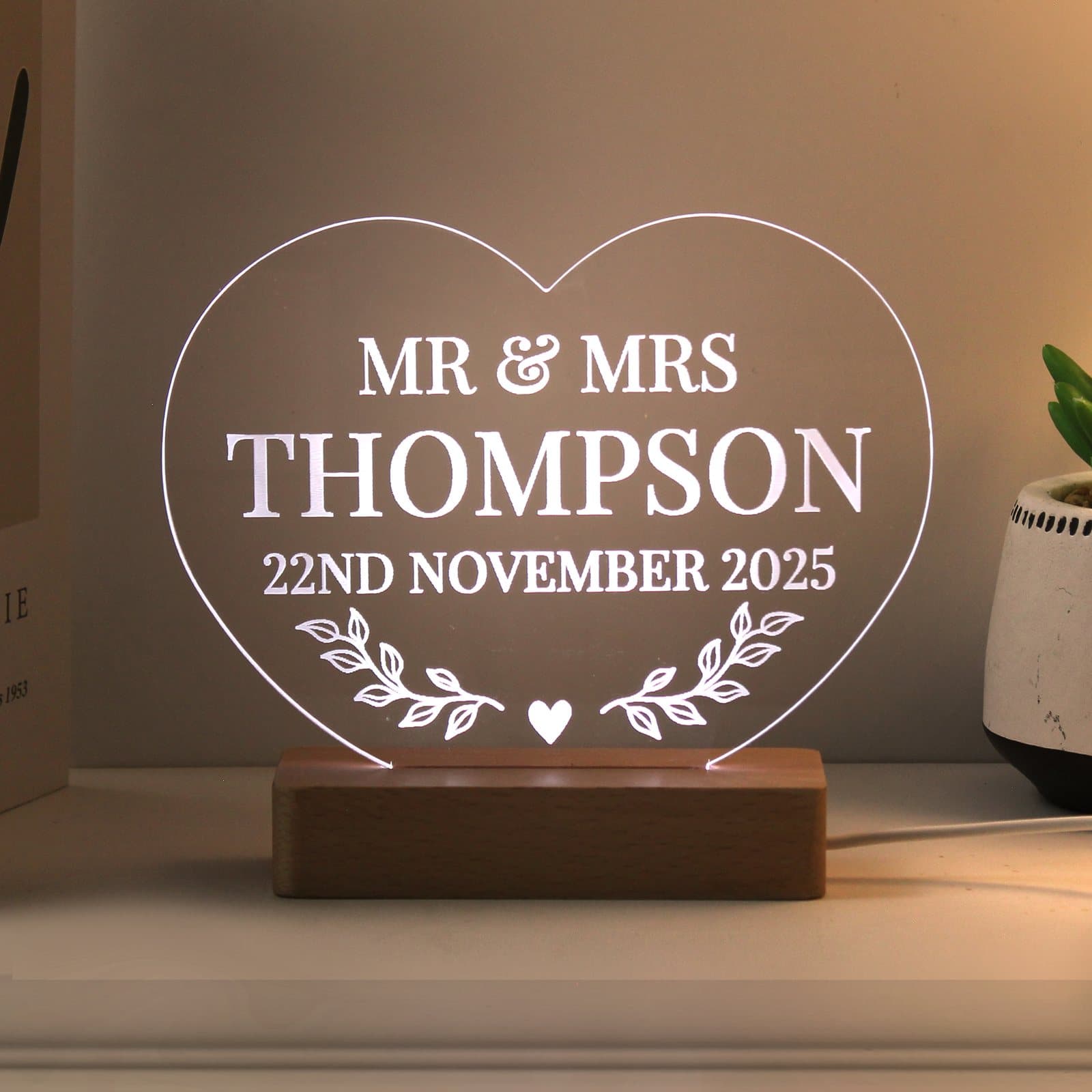 Heart-shaped LED sign with three lines of text on a small base