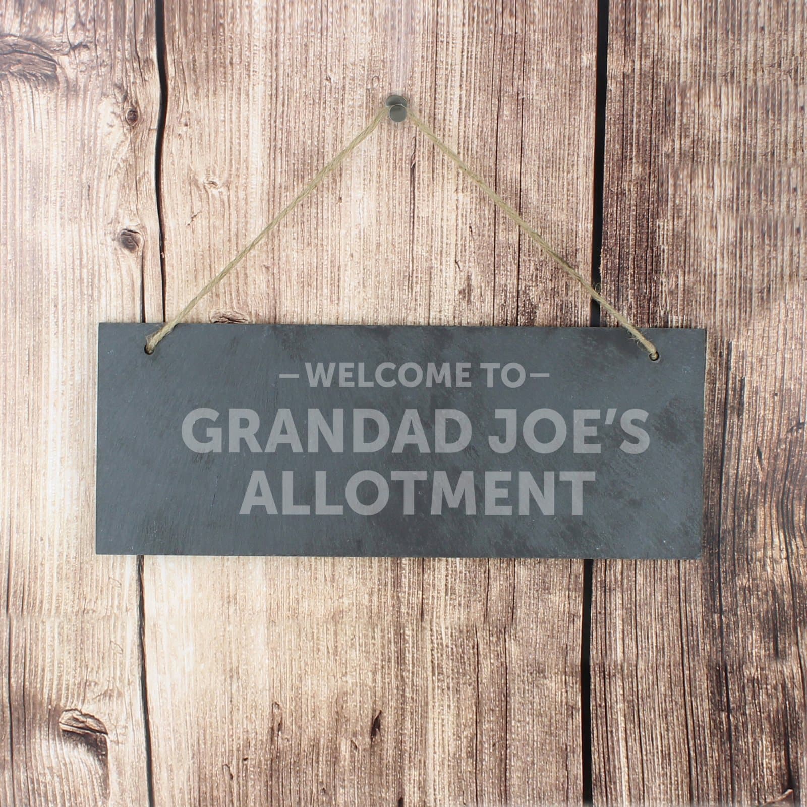 Hanging slate plaque with Welcome To wording and natural string