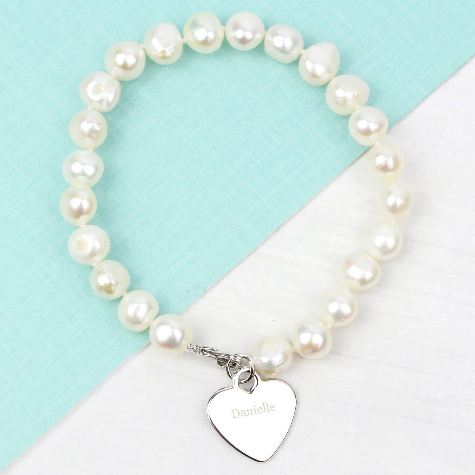 White freshwater pearl bracelet with a rhodium plated heart tag
