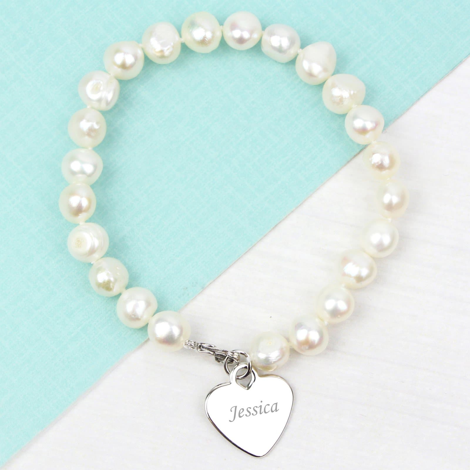 White freshwater pearl bracelet with a rhodium plated heart tag