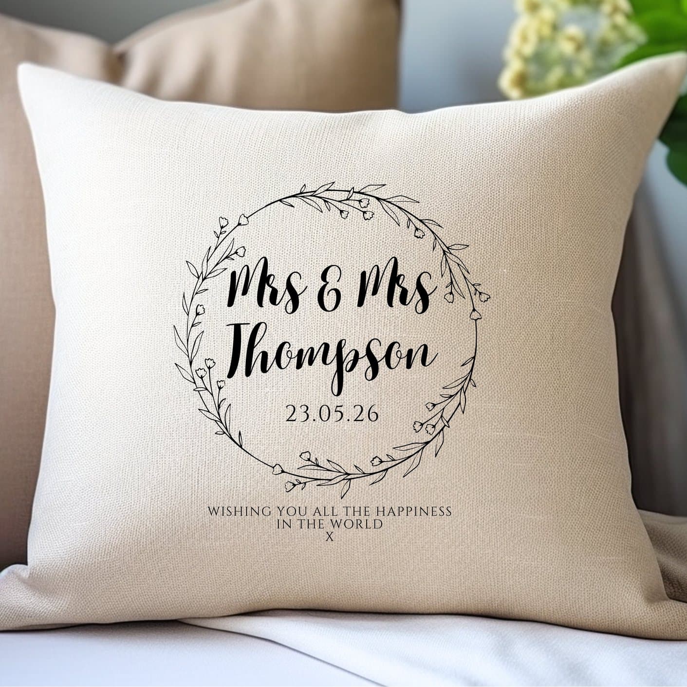 Cream cushion with a wild flower circle and black script wording