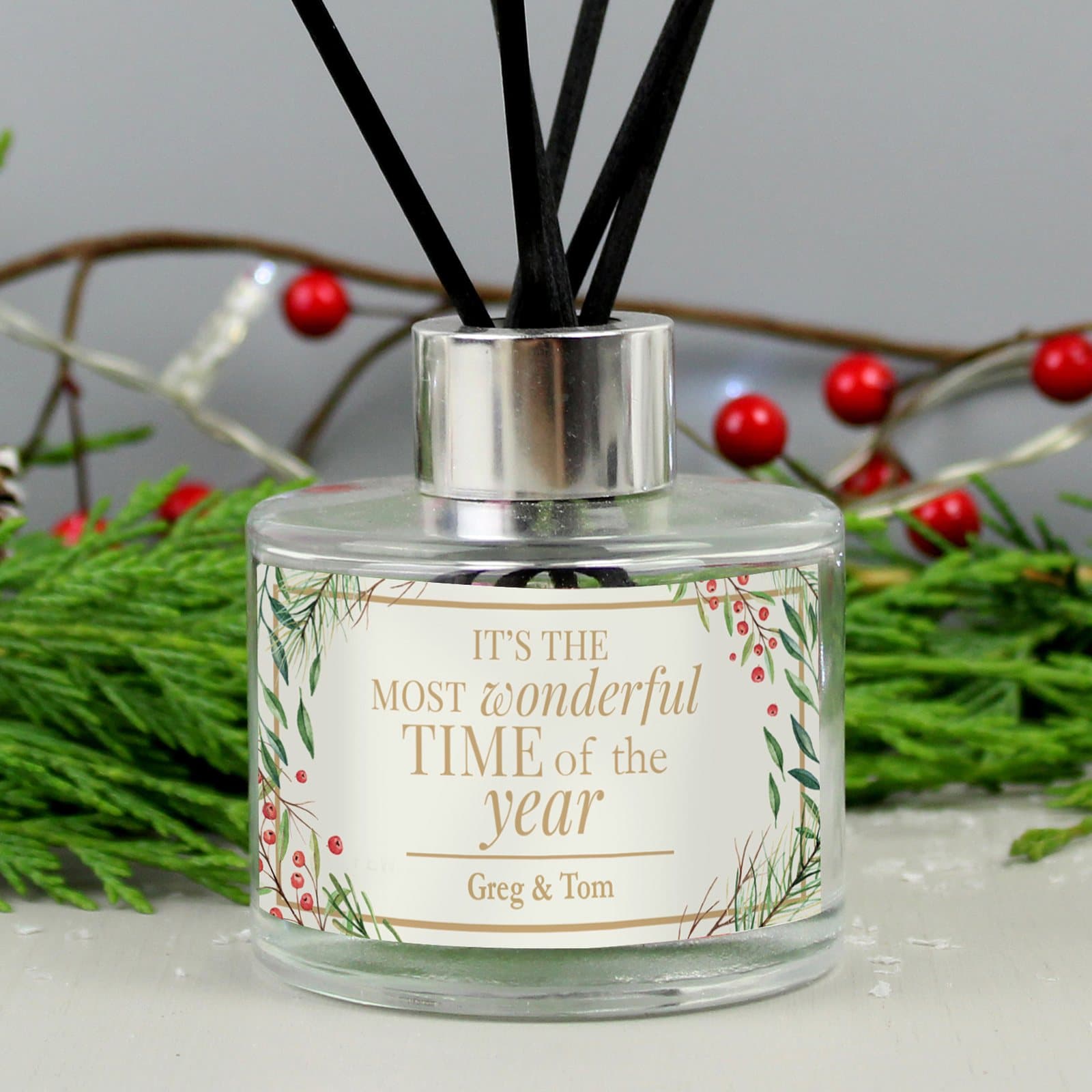 Glass Christmas reed diffuser with reeds and festive text and a personalised line
