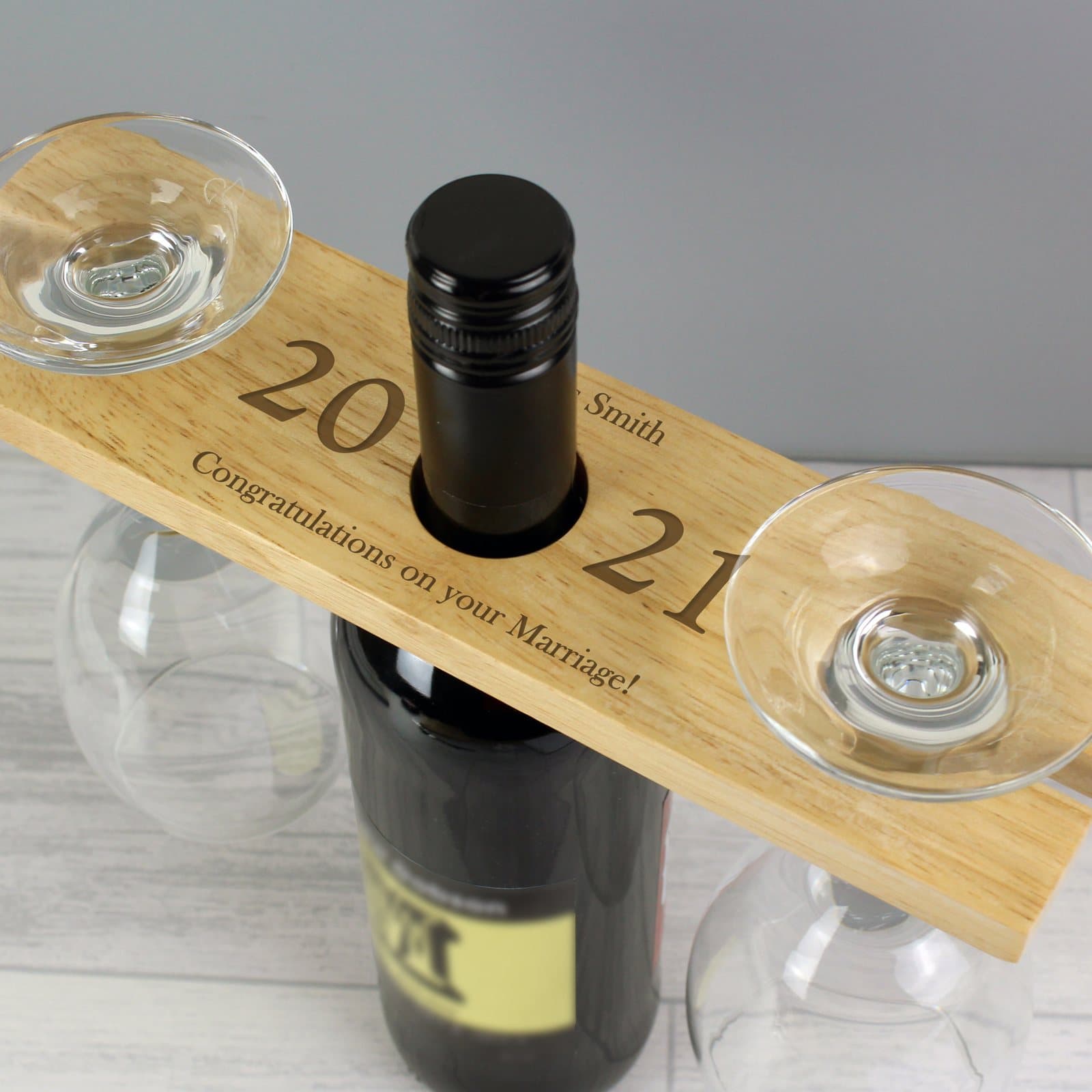 Personalised wooden wine glass and bottle holder with a message and year