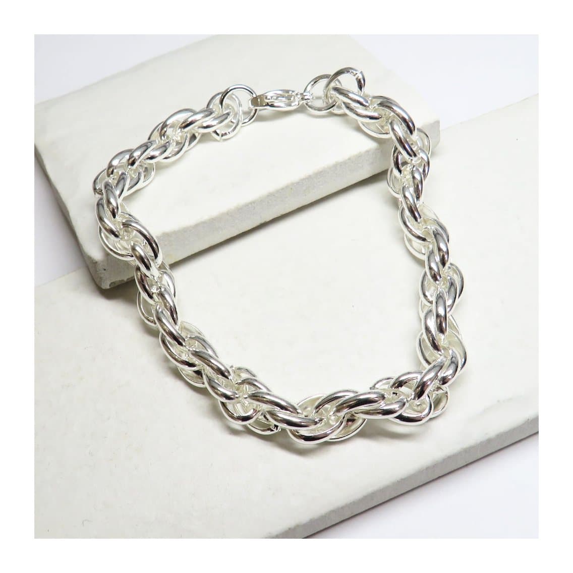 Twisted silver bracelet in bright silver colour on a plain background